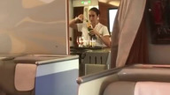 Stewardesa Emirates Airlines nalewa szampana