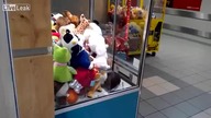 Cygańskie dziecko okrada automat z maskotkami