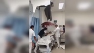 LiveLeak - Docs Hold Umbrella Over Hospital Patient As Water Pours In
