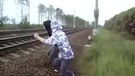 Dwóch chłopaków kładzie się pod jadący pociąg