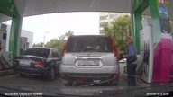 Kobieta myli samochód na stacji benzynowej.
