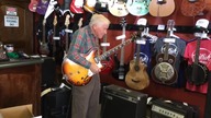 81 latek daje świetny popis gitarowy w sklepie.