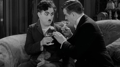 With the aid of a wealthy erratic tippler, a dewy-eyed tramp who has fallen in love with a sightless flower girl accumulates money to be able to help her medically.