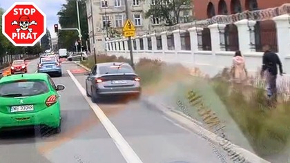 Cwaniak w Skodzie wyprzedza pasem ruchu dla rowerów i przejeżdża na czerwonym świetle.  STOP PIRAT