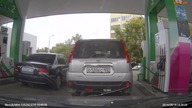Kobieta myli samoch&oacute;d na stacji benzynowej  