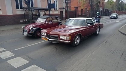 Kaczka i Chevrolet lub Cadillac stoją na światłach