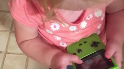 Dzieciak pr&oacute;buje grać na Game Boyu