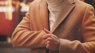Męska stylizacja z granatowym garniturem w kręte i brązowym płaszczem